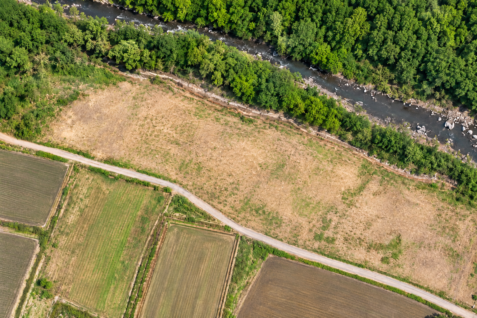 山林と川、道路、農地のある敷地の航空写真風AI画像